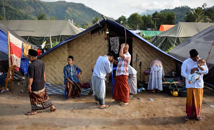 Sejumlah warga korban gempa berrsalaman usai melaksanakan Salat Idul Adha 1439 H di Posko Pengungsian Desa Kekait, Kecamatan Gunungsari, Lombok Barat, NTB, Rabu 22 Agustus 2018. Sebanyak 1400 jiwa pengungsi korban gempa bumi di tenda pengungsian tersebut merayakan hari raya Idul Adha di tenda pengungsian dan menyembelih hewan kurban sebanyak 30 ekor sapi sumbangan dari para donatur.(foto: ahmad subaidi/antara)