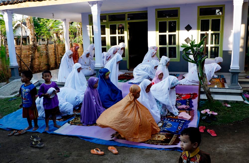 Jamaah Aboge perempuan shalat yang tak kebagian tempat di halaman mushalla dengan cara menggelar tikar. (Foto: Isa/ngopibareng.id)