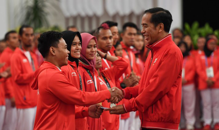 Presiden Joko Widodo (kanan) menyalami dan memberikan buku tabungan kepada lifter Eko Yuli Irawan (kiri) saat pemberian bonus kepada atlet peraih medali di Istana Negara, Jakarta, Minggu 2 September 2018. Pemerintah memberikan bonus kepada para atlet yang berhasil meraih medali dalam ajang Asian Games 2018. (Foto: Antara/Hafidz Mubarak)