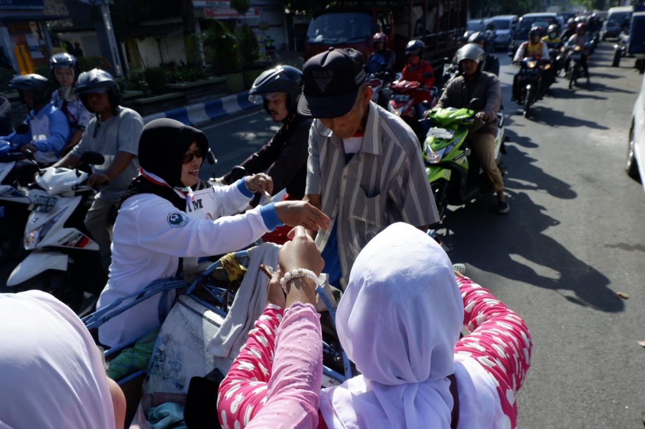 Seorang tukang becak kena razia anti rokok. Rokoknya pun diganti dengan nasi bungkus. (Foto: Ikhsan/ngopibareng.id)