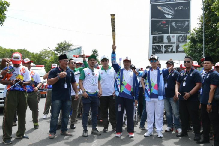 Menteri Pemuda dan Olahraga Imam Nahrawi didampingi Ketua Umum Panitia Penyelenggara Asian Para Games 2018 (INAPGOC) membawa obor dalam pawai obor Asian Para Games 2018 di Kota Ternate. Foto : kemenpora