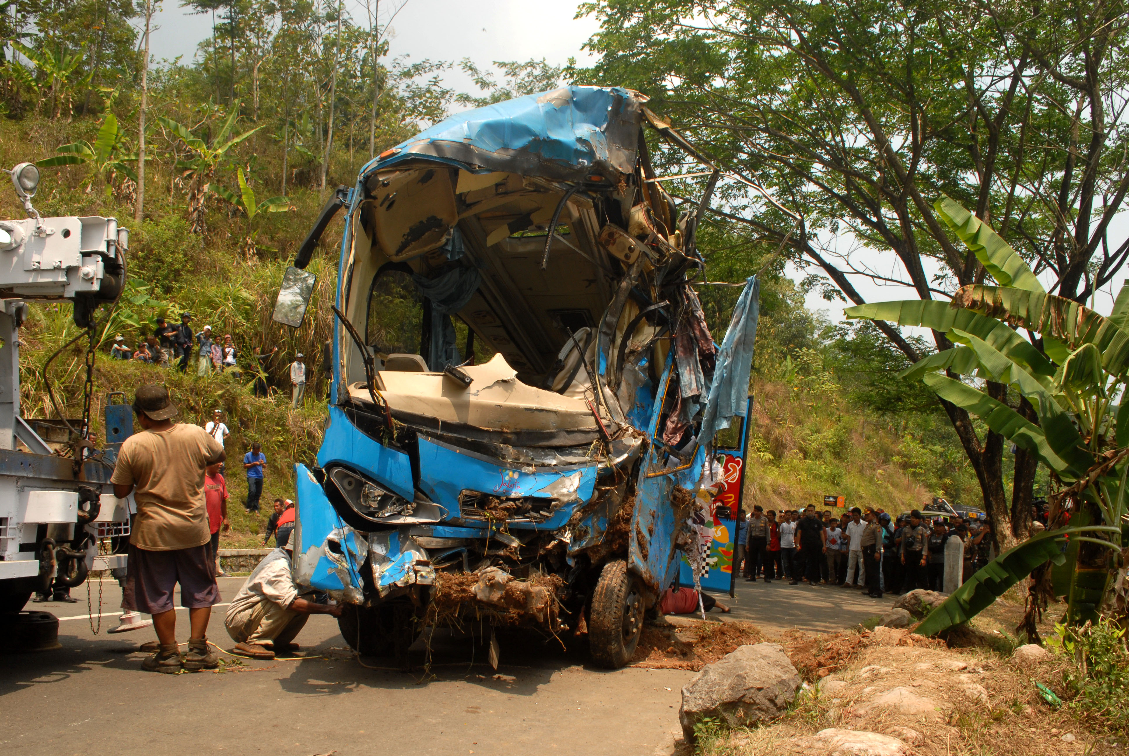 Petugas mengevakuasi mini bus berpenumpang puluhan wisatawan yang masuk jurang di Tanjakan Letter S, Kampung Bantarselang, Kecamatan Cikidang, Sukabumi, Jawa Barat. (Foto: Antara/Budiyanto)