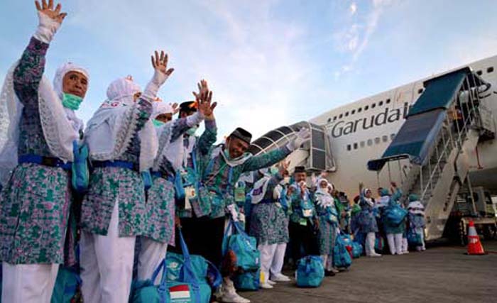 Jamaah haji melambaikan tangan sebelum naik ke pasawat yang akan membawa mereka kembali ke tanah air. (Foto: Antara)