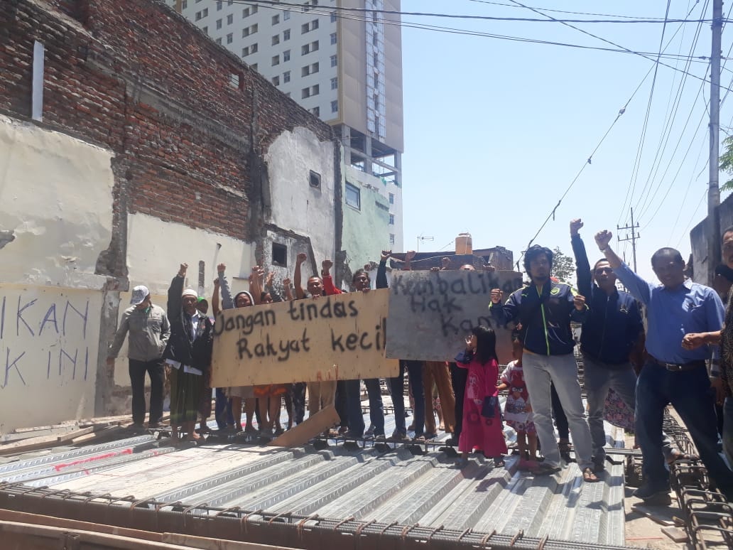 Warga aksi di atas jalan akses apartemen yang dibangun di atas selokan. (Foto: Roesdan/ngopibareng.id)