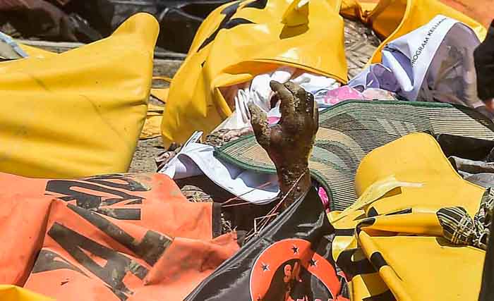 Tangan menengadah ke langit, dalam tumpukan kantong jenazah akibat korban gempa dan tsunami Palu.  (Foto: Muhammad Adimaja/Antara)