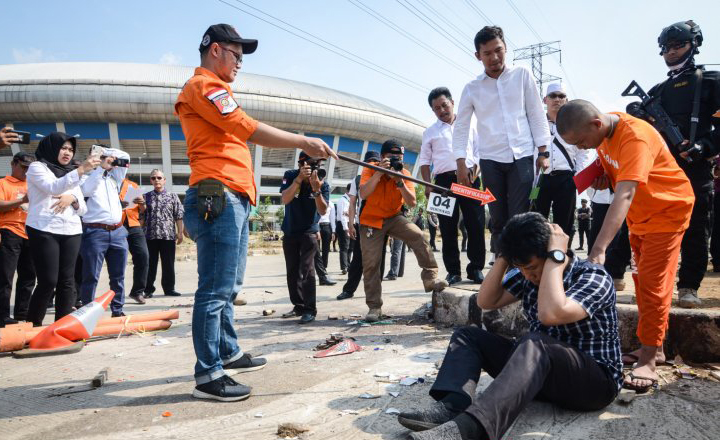 Seorang tersangka memperagakan tindakannya saat rekonstruksi pengeroyokan yang dilakukan oleh oknum bobotoh terhadap seorang suporter Persija, Haringga Sirla di Stadion GBLA, Bandung, Jawa Barat, Rabu 26 September 2018. Rekontruksi tersebut dilakukan ‎untuk mendapatkan gambaran jelas tentang terjadinya tindak pidana pengeroyokan hingga menghilangkan nyawa Haringga Sirla tersebut, serta untuk menguji kebenaran keterangan para tersangka dan saksi. (Foto: Antara/Raisan Al Farisi)