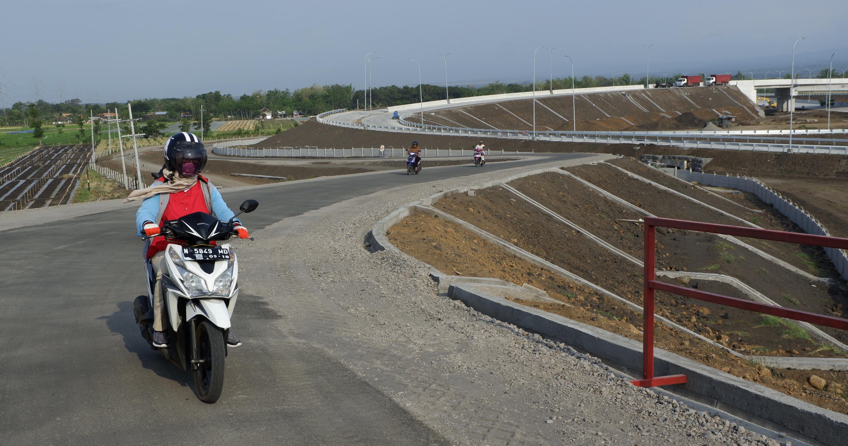 Pengendara motor melintasi jalan warga di atas Tol Pasuruan-Probolinggo (Paspro) Seksi III di Leces, Kabupaten Probolinggo. (Foto: Ikhsan/ngopibareng.id)