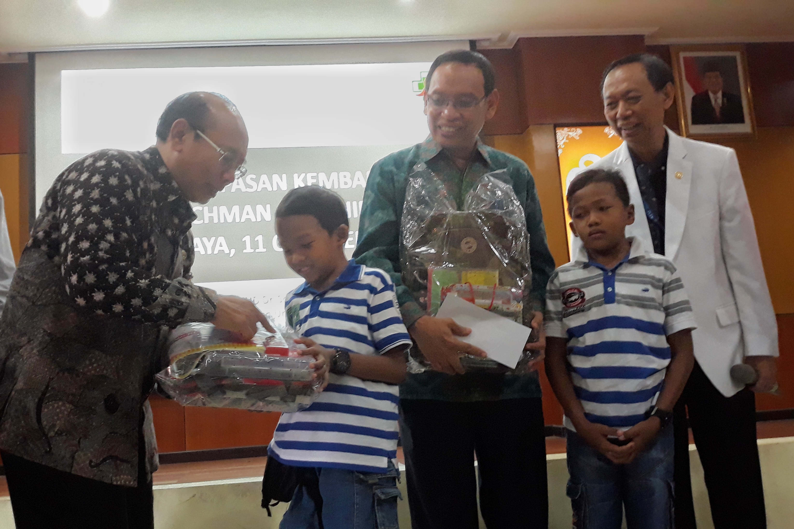 Pemberian bingkisan untuk Rochman-Rochim. Dari kiri: Direktur RSUD Dr Soetomo, Rektor Unair, Rochman, Rochim, dan Ketua PPKST.