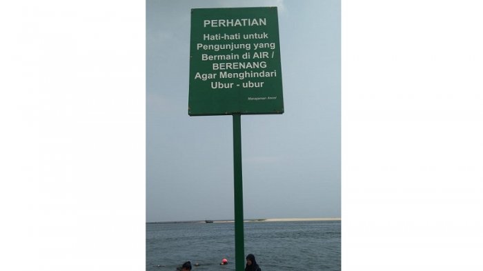 Papan pengumuman di Pantai Ancol, Jakarta Utara.