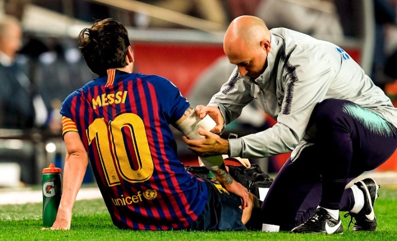 Lionel Messi mendapat pertolongan pertama dari tim medis dengan di gips lengan kanannya. Foto: Reuters.