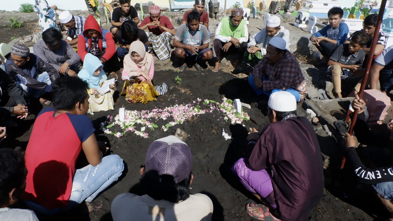 Para pelayat berdoa di makam Moch, Rohim. ABK yang tewas. (Foto: Ikhsan/ngopibareng.id)