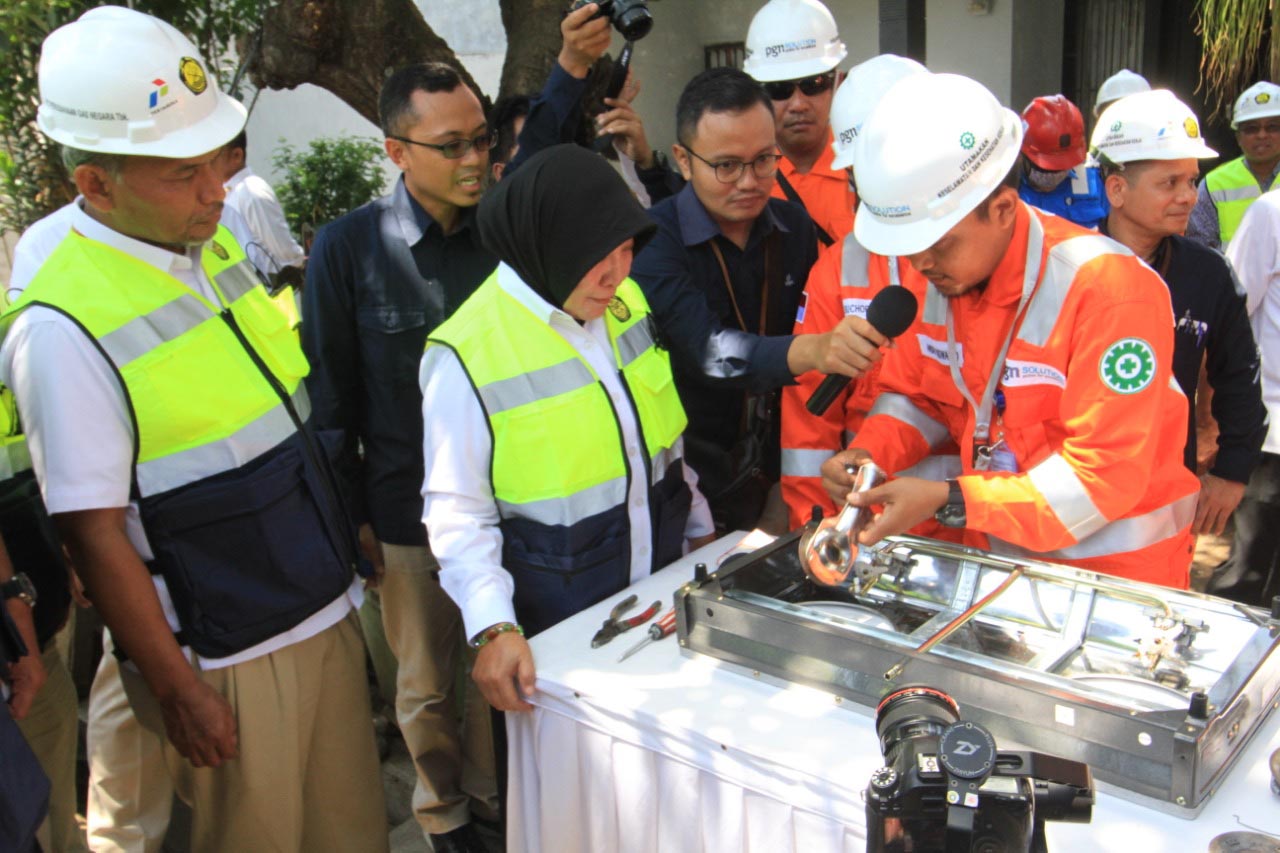 Wali Kota Rukmini menyaksikan petugas membenahi kompor yang menggunakan bahan bakar gas. (Foto: Ikhsan/ngopibareng.id)