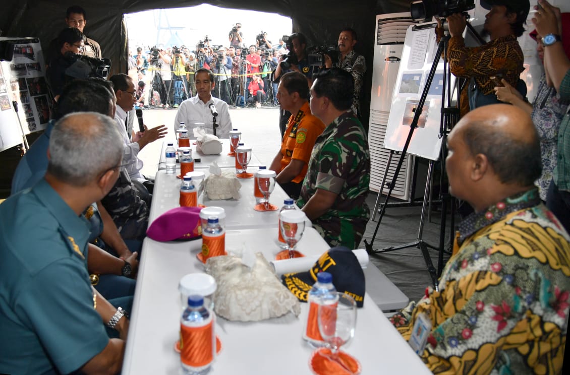 Presiden Joko Widodo mendengarkan paparan Menteri Perhubungan Budi Karya Sumadi, di posko terpadu evakuasi Lion Air JT-610 Jakarta International Container Terminal (JICT) 2, Tanjung Priok, Jakarta Utara.