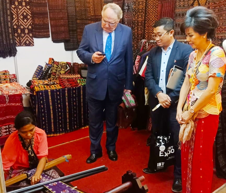 Hans De Brabander, Head of The Economic Department/Counsellor dari Consulate of The Netherlands, menunggui perajin tenun sedang beraksi. Selain dia hadir sebagai narasumber dalam Forum International Partner Opportunities di Garden Palace, Surabaya. Foto:IBT Expo for ngopibareng.id