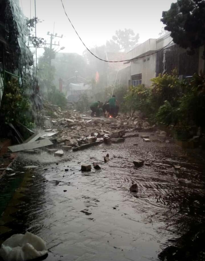 Beberapa warga tanpak sedang mengevakuasi salah satu korban yang tertimpa bangunan GOR Cahaya Tengger. 