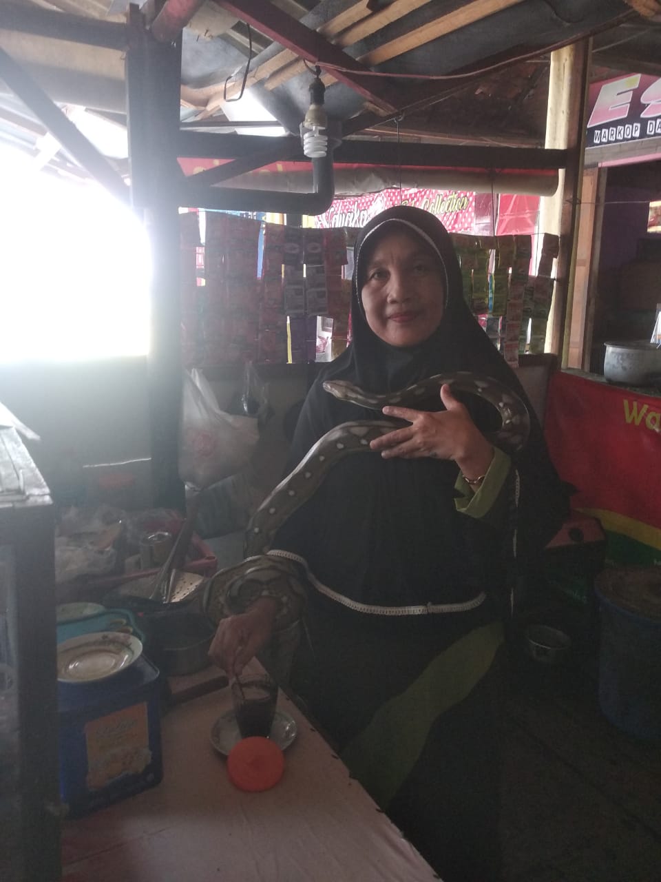 Bikin kopi juga menggendong ular. foto:totok martono