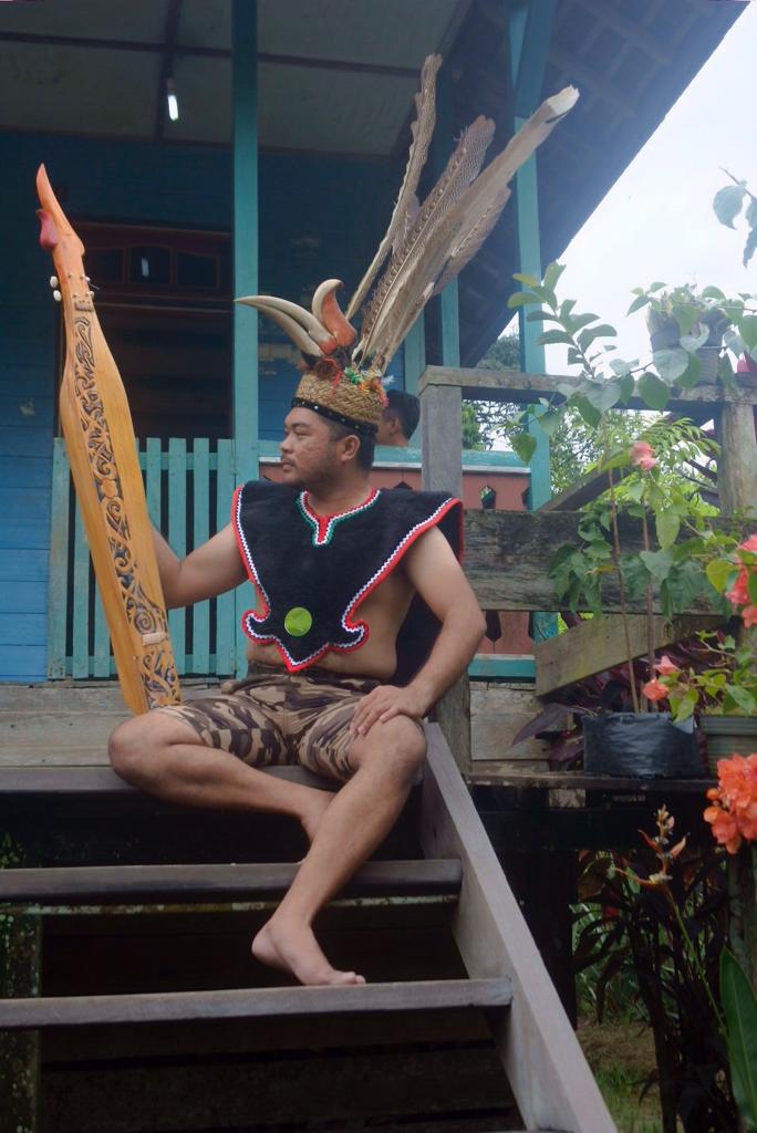 Lelaki dayak dengan alat musik. foto:pesona indonesia