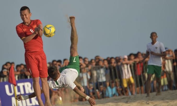 I Ketut Sudiartawan (kedua kanan) berebut bola dengan pemain Vietnam Le Quy Long Vy dalam pertandingan Sepak Bola Pantai AFF 2018 di Pantai Tanjung (kanan) Benoa, Nusa Dua, Bali, Senin (19/11). Foto: antara