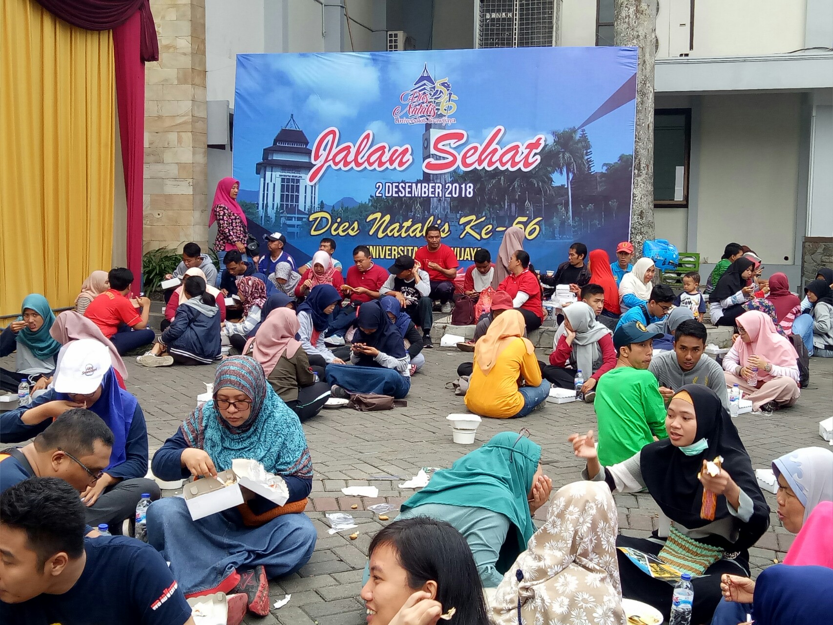 Peserta jalan sehat menikmati makanan gratis yang disediakan.