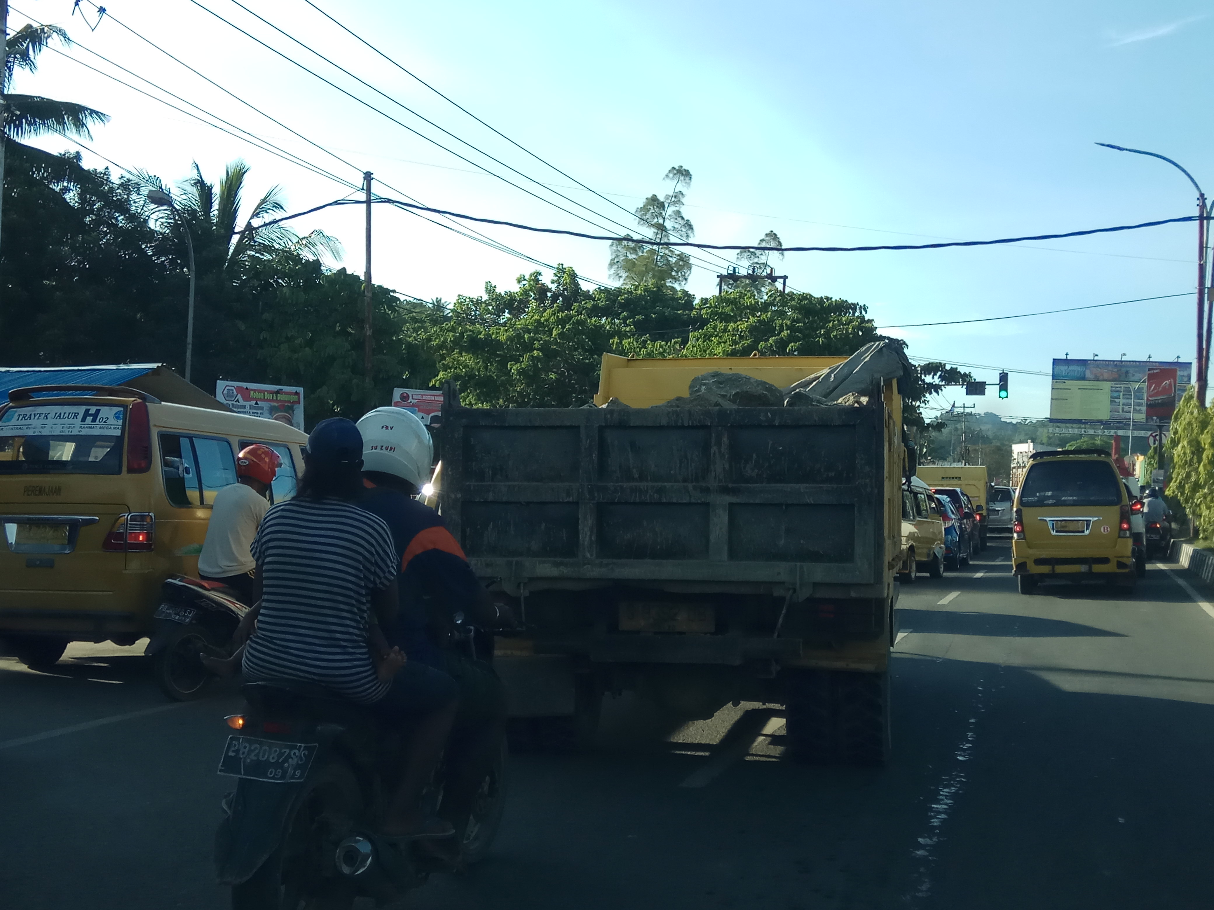 Truk mengangkut material tanah dengan bak terbuka di Kota Sorong. Debunya beterbangan ke mana-mana. Akibat bisa menyumbat saluran pembuangan. (Foto: Amir/ngopibareng.id)