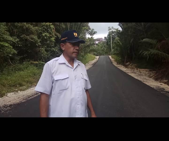 Johan Usmany ST, Asisten Teknik Satker PJN Wilayah III Maybrat, Papua Barat dengan latar belakang jalan ruas Kumurkek- Ayawasi-Senopi yang teraspal mulus. (Foto: Amir/ngopibareng.id)