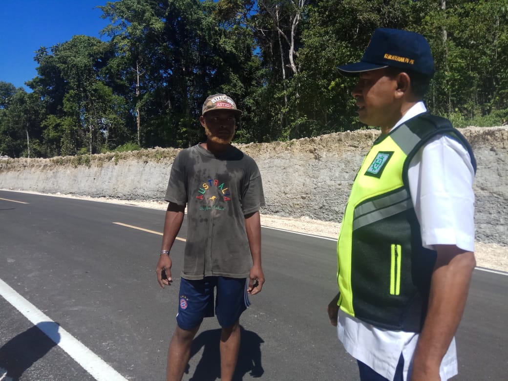 , Johan Usmany ST, Asisten Teknik, PJN III Maybrat sedang berbincang dengan pengawas pekerja. (Foto: Amir/ngopibareng.id)