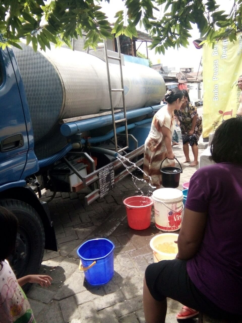 Sejumlah warga mengambil dari truk PDAM Surya Sembada. (Foto: Haris/ngopibareng.id)