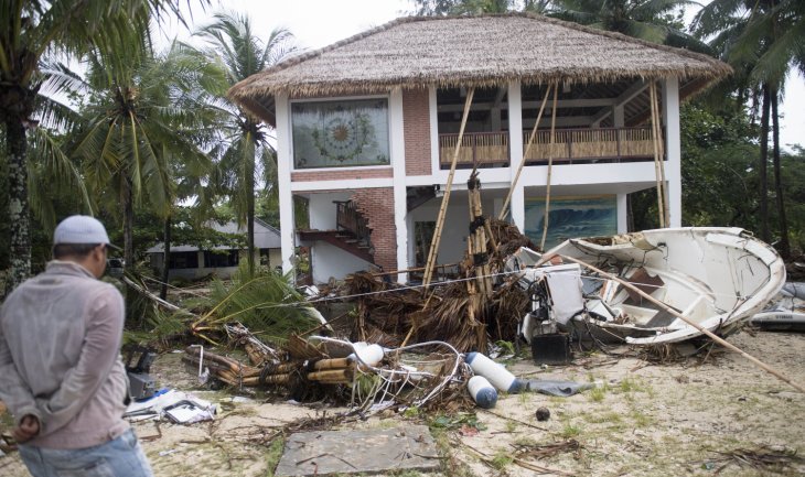 Warga berada di depan bangunan yang terdampak bencana Tsunami di Pantai Tanjung Lesung, Banten, Jawa Barat, Minggu 23 Desember 2018. (Foto: Antara/Akbar Nugroho Gumay)