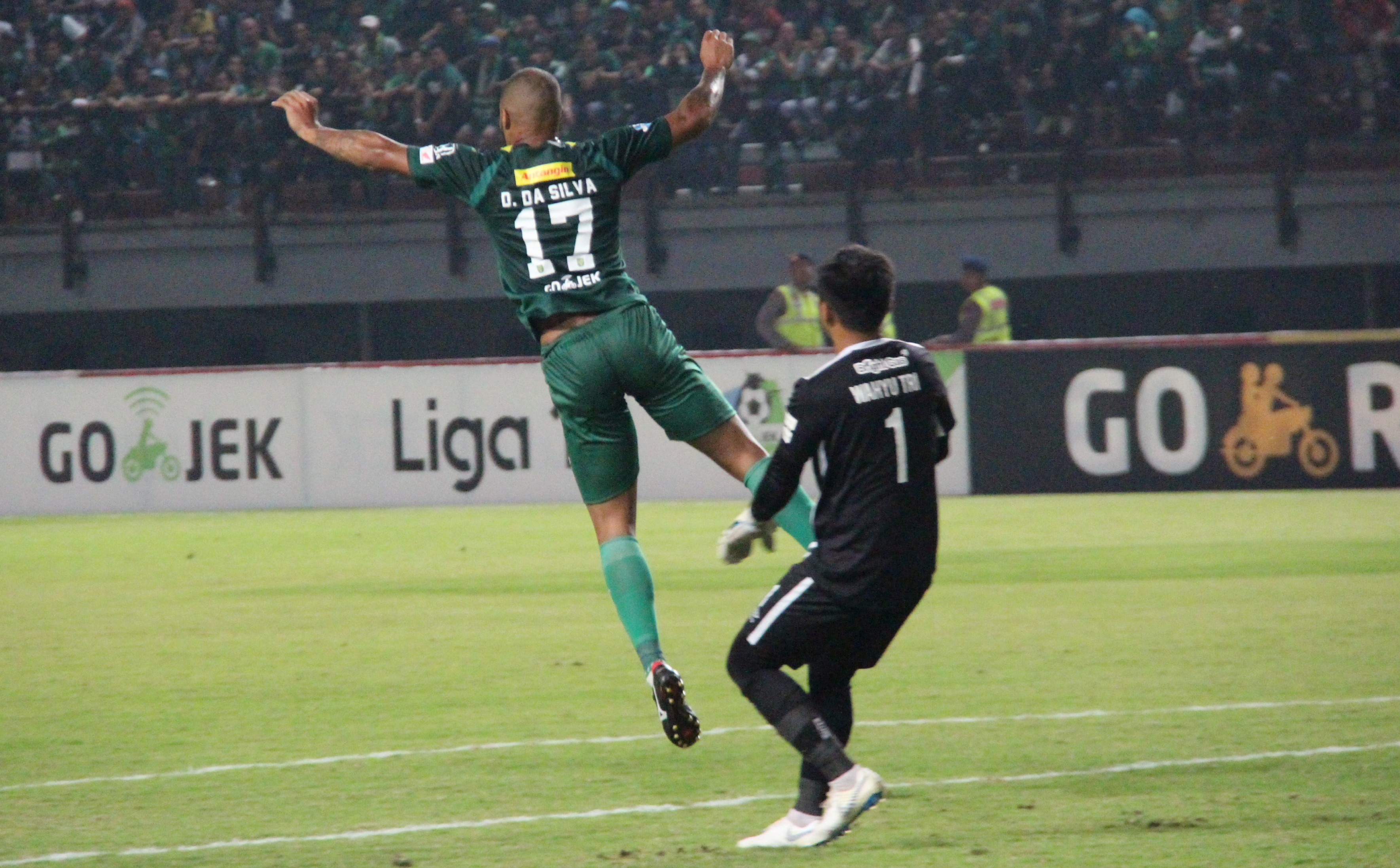 Kiper Bhayangkara, Wahyu Tri (kanan), saat berduel dengan David da Silva. (foto: Haris/ngopibareng)