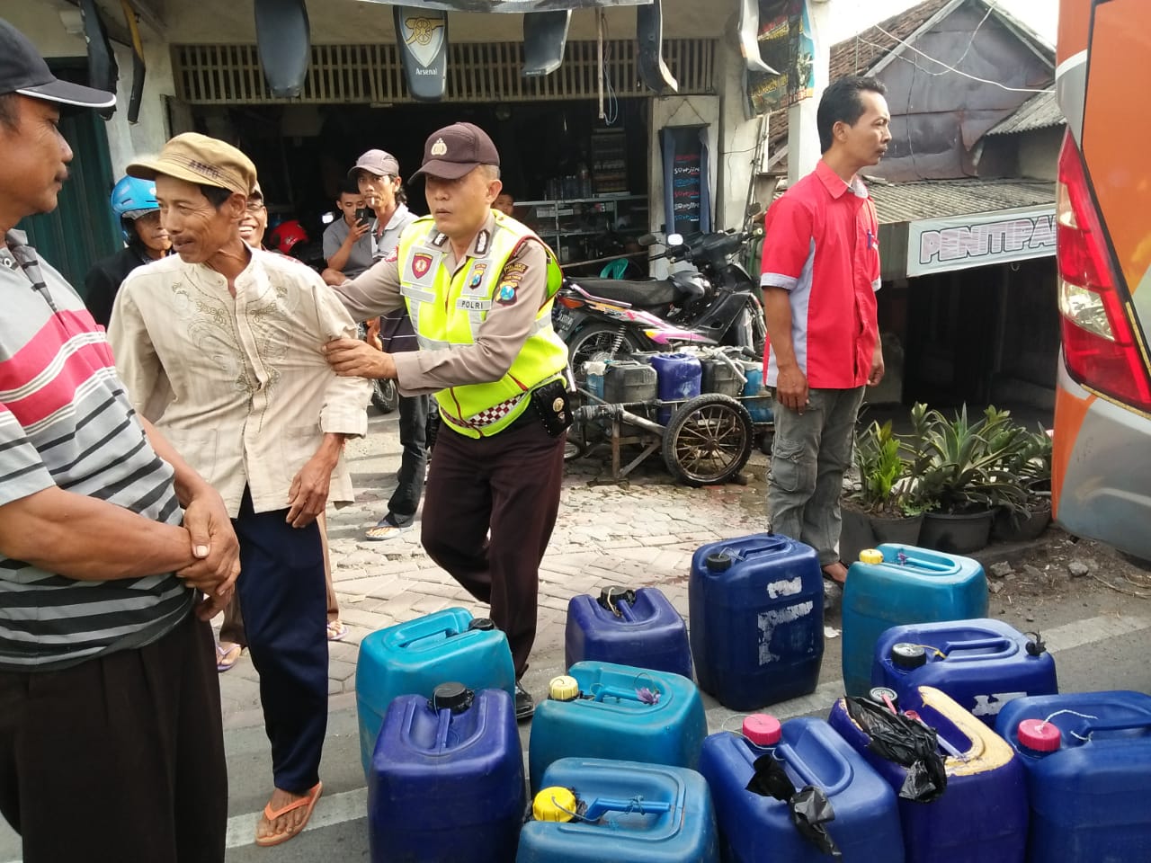 Petugas saat mengamankan ratusan liter tuak. (Foto:Totok/ngopibareng.id)