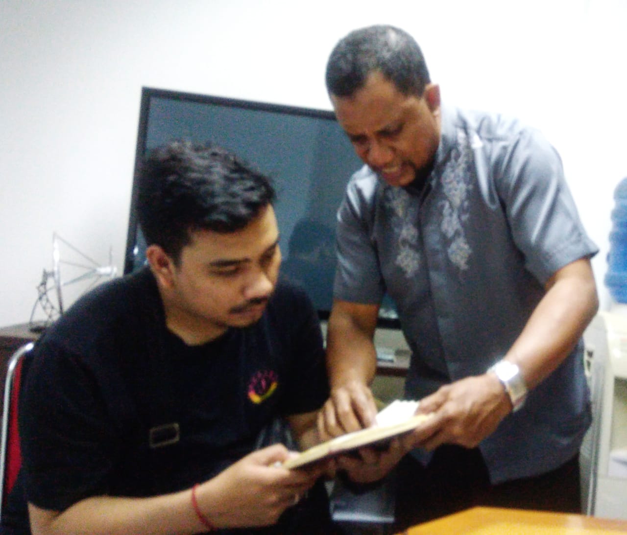Kaynama (berdiri) melayani tamunya yang ingin tahu tentang Islam. (Foto Asmanu/ngopibareng.id)