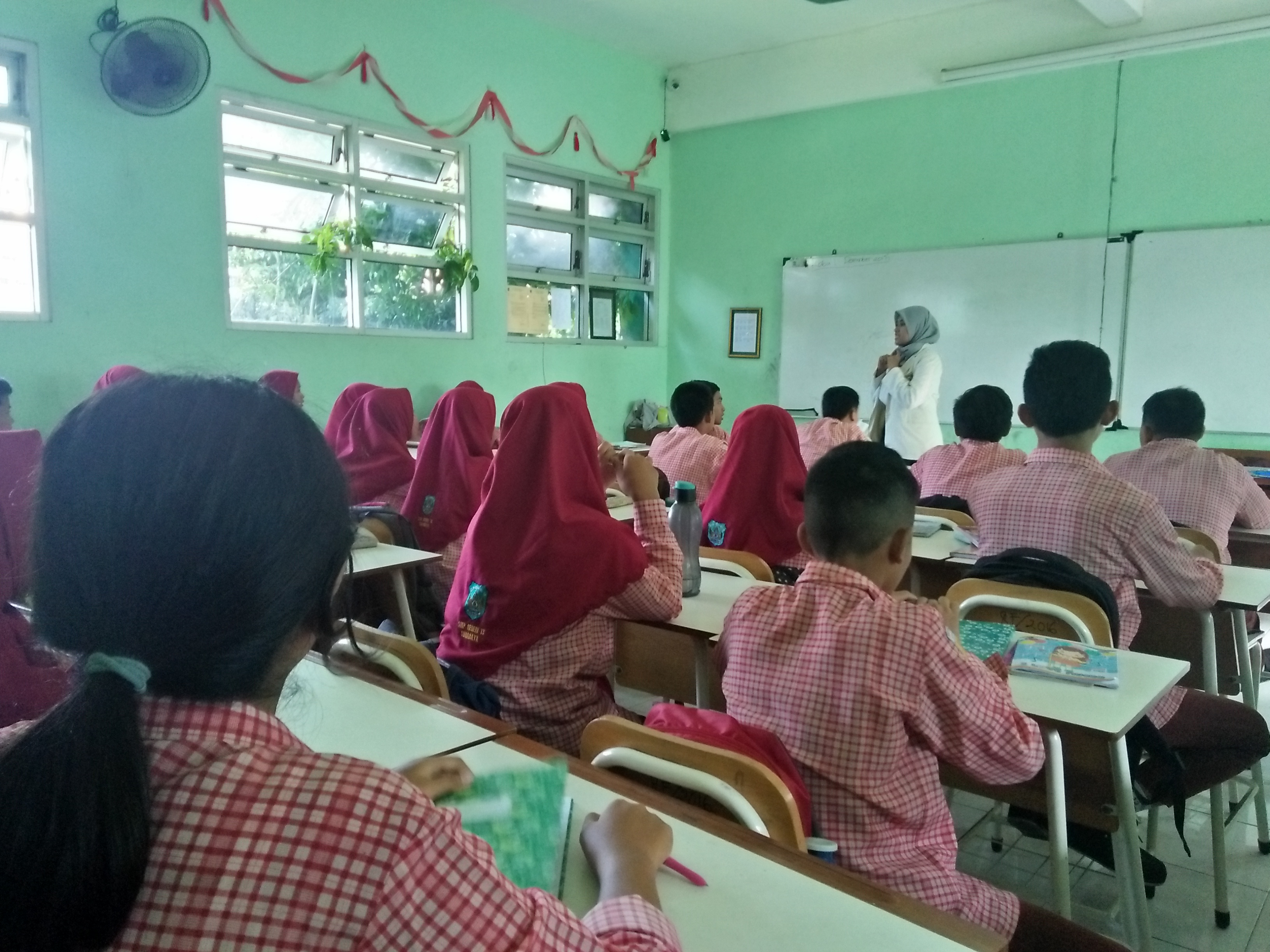 Mahasiswa Stikosa-AWS memberikan sosialisi kepada siswa SMPN 13 Surabaya tentang pentingnya Bahasa Indonesia, Rabu 2 Januari 2018. (Foto: Amanah/ngopibareng.id) 