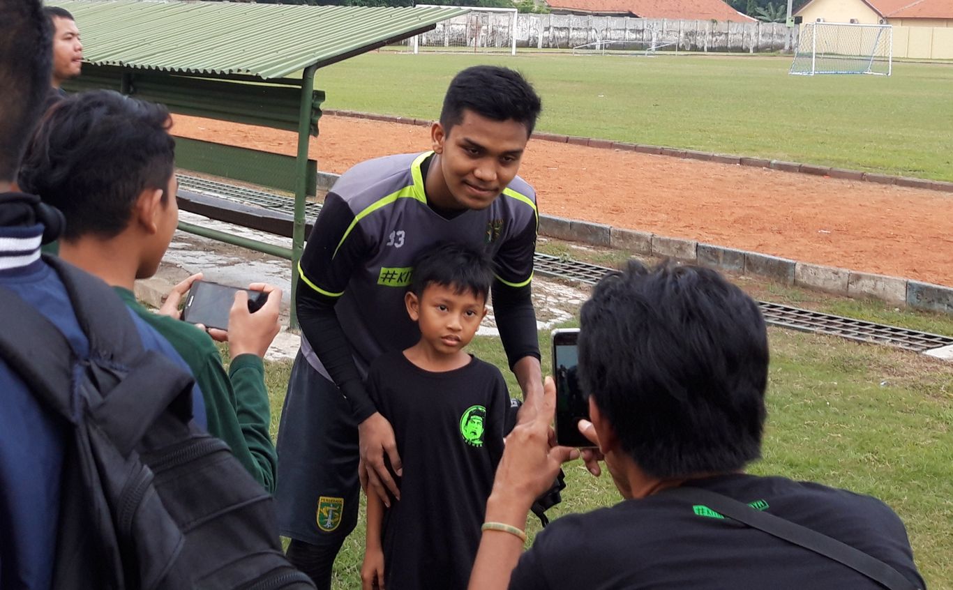 Kiper Persebaya, Miswar Saputra saat diajak foto Bonek Mania. (foto: Haris/ngopibareng.id)