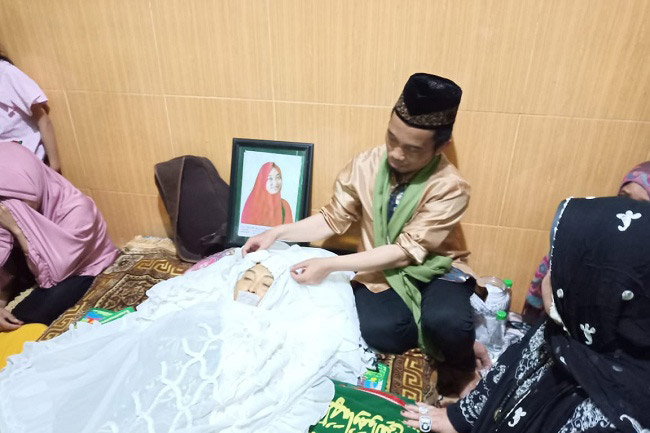 Ustadz Maulana berada disamping jenazah sang istri.