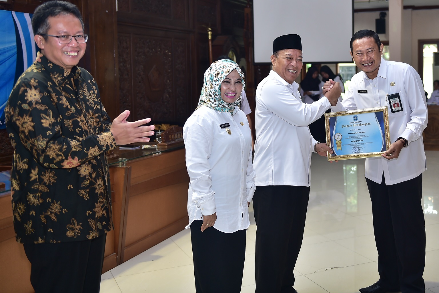 Bupati Fadeli saat menyerahkan piagam penghargaan ke Sekda Yuhronur Efendi untuk sekretariat daerah katagori A (memuaskan) (Foto :Totok/ngopibareng.id)