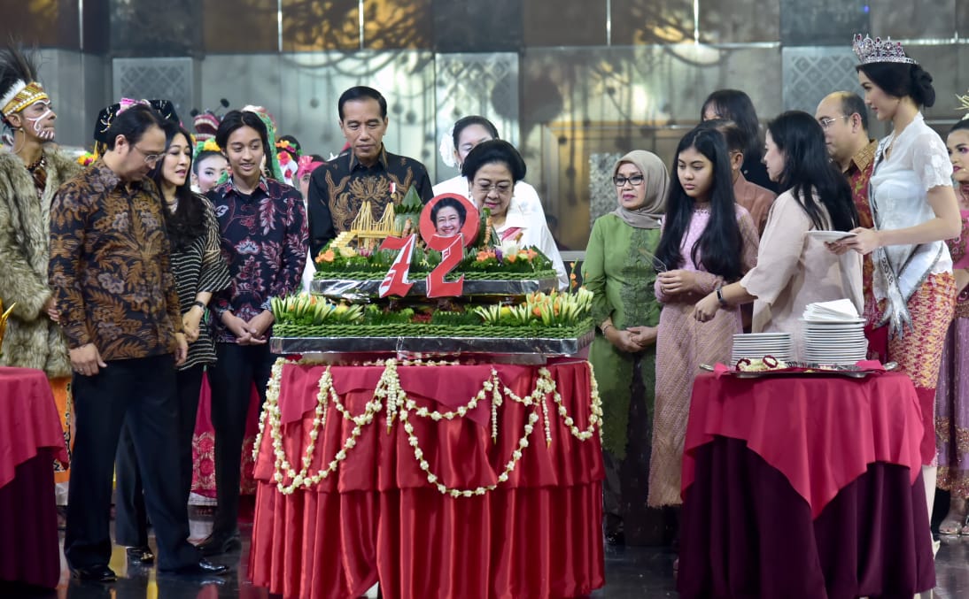 Presiden Joko Widodo dan Wakil Presiden Juduf Kalla, memperlihatkan hadiah buku biografi Megawati. ( Foto: setpres for ngopibareng.id)).