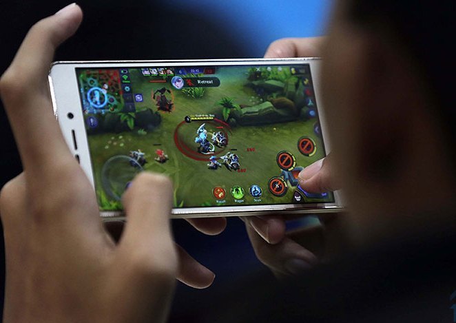 Gamer sedang memainkan Mobile Legend di telepon genggamnya. (Foto: urbandigital)