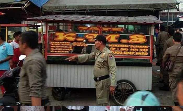 Petugas Pemkot Padang menutup lapak sate padang KMS di Simpang Haru, Padang, kemarin, karena didudga menjual sate daging babi. (Foto:Tribun)