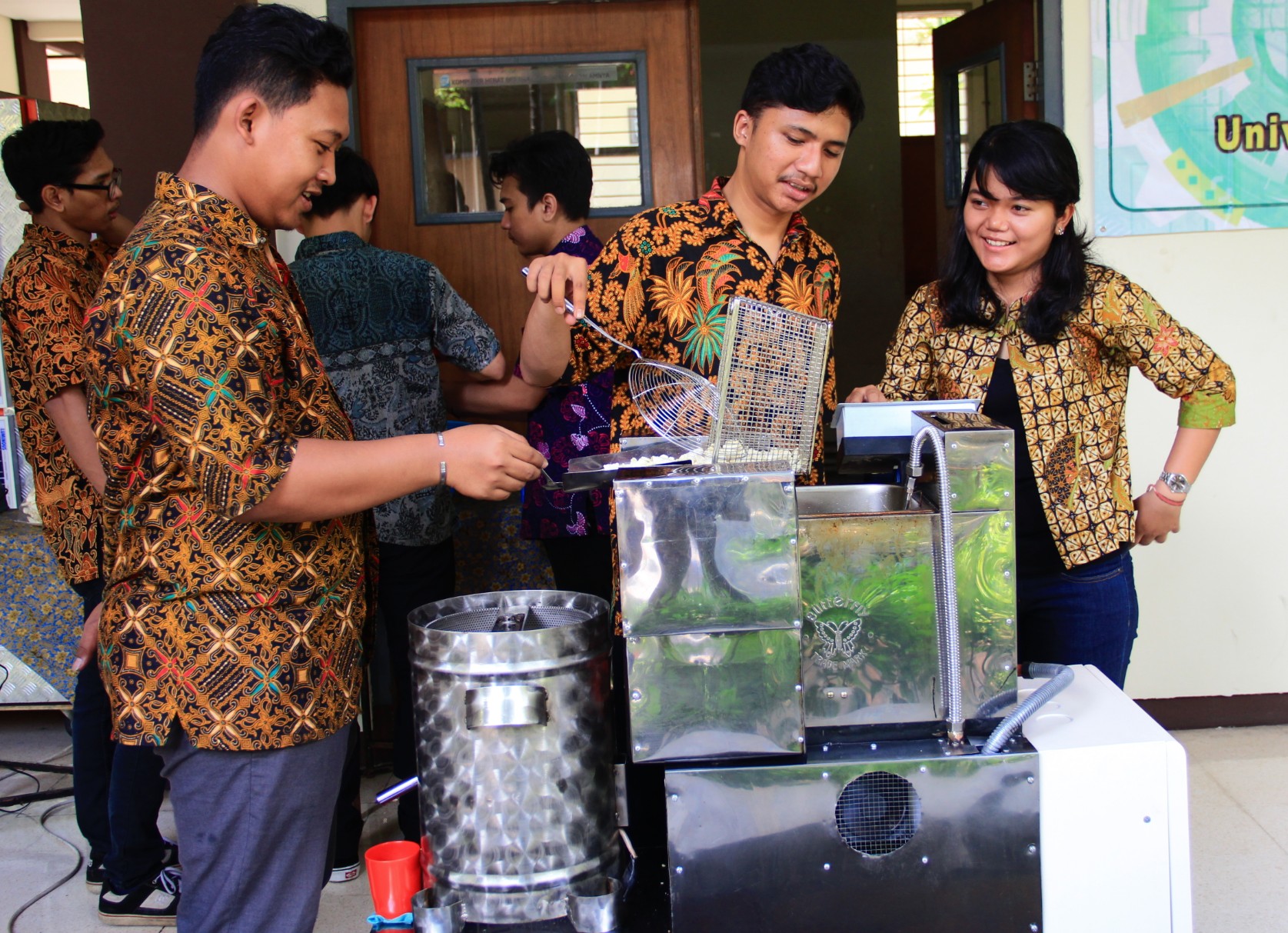 Para mahasiswa UKWMS yang tergabung dalam tim TTG saat mempraktekan kerja alat penggoreng kerupuk otomatis (Foto: Istimewa) 