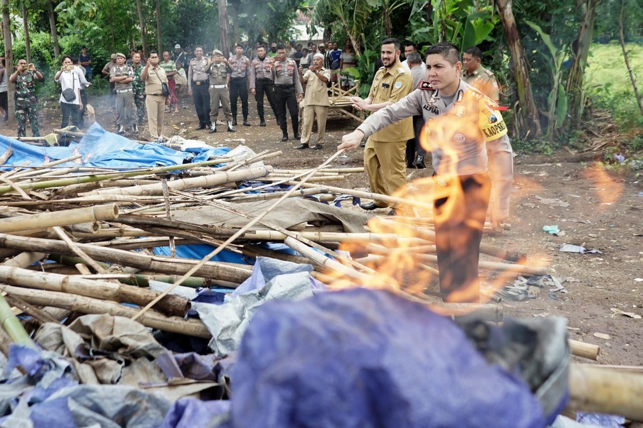 Kapolresta AKBP Alfian Nurrizal  (kanan) mendampingi Wali Kota Habib Hadi Zainal Abidin membakar tempat judi sabung ayam di Jrebeng Kulon. (Foto: Polresta/ngopibareng.id)