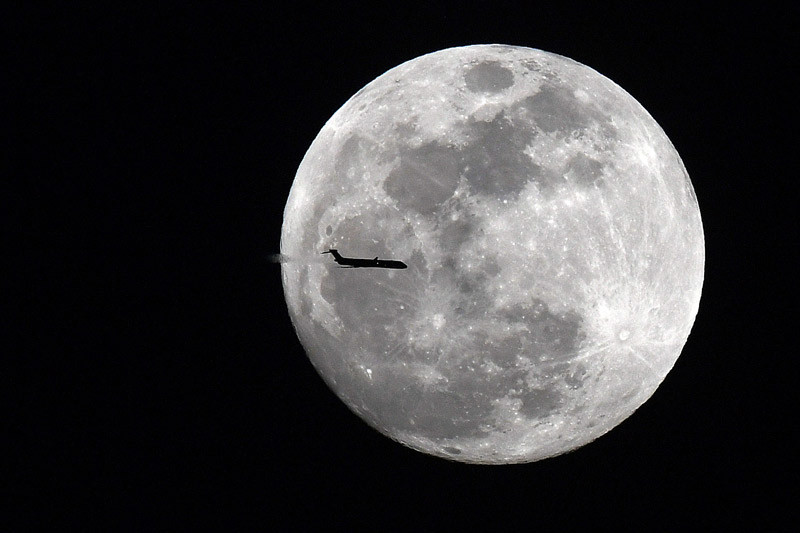 Sebuah pesawat melewati fenomena Supermoon