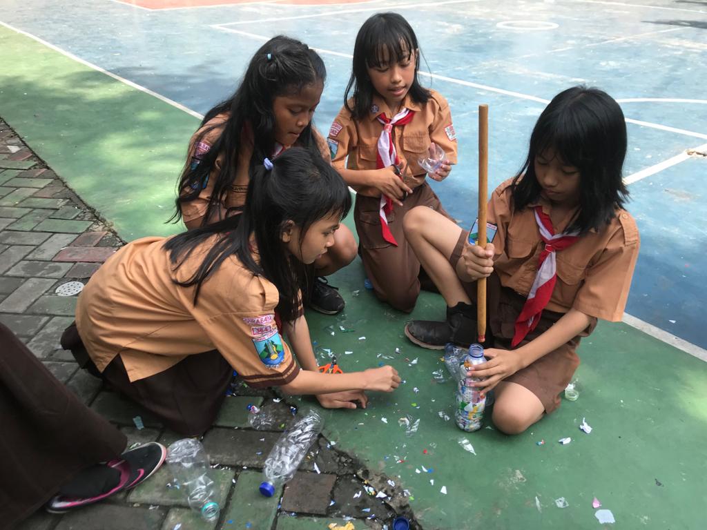 Anak-anak SDN Kaliasin 1 sedang memenuhi botol dengan sampah plastik.  (Foto:Istimewa)