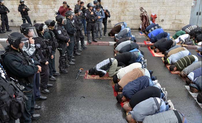 Tentara Israel menghadang di depan warga Palestina yang shalat di dekat Bab Ar-Rahmah komplek masjid Al Aqsha, Jerusalem, Palestina, sebelum menghajar mereka. (Foto:wafa)