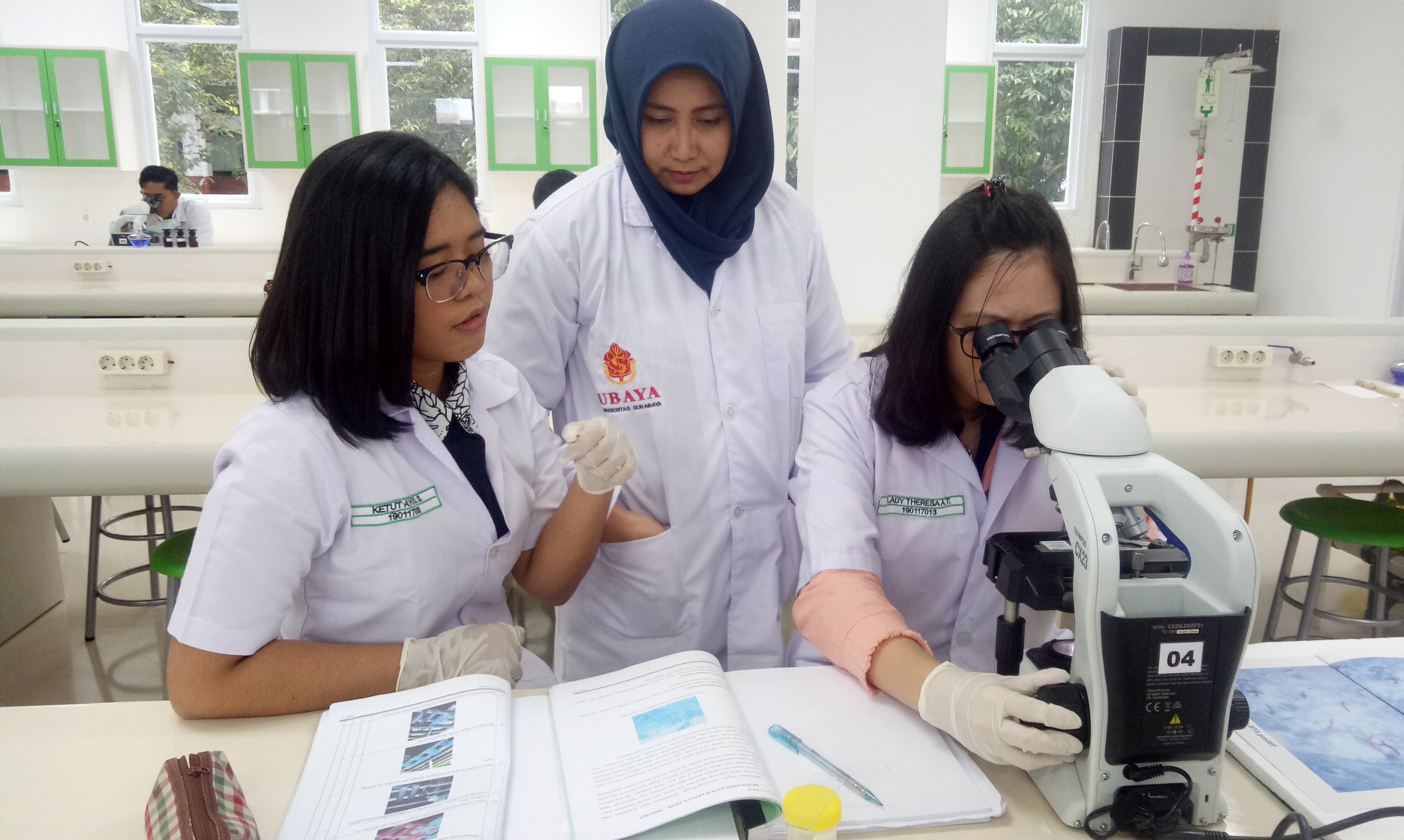 dr. Risma Ikawaty, Ph.D (tengah)  saat memberikan bimbingan mahasiswa yang sedang praktikum pemeriksaan TB.  (Foto: Pita/ngopibareng.id)