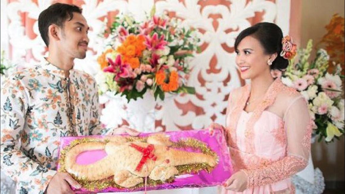 Pengantin Betawi dengan seserahan roti buaya. (Foto: yukepo.com)