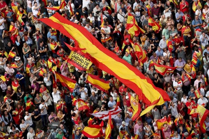 Pengunjuk rasa mengibarkan bendera Spanyol dan berteriak di depan balai kota dalam sebuah demonstrasi mendukung persatuan Spanyol. (Foto: Reuters via Antara)