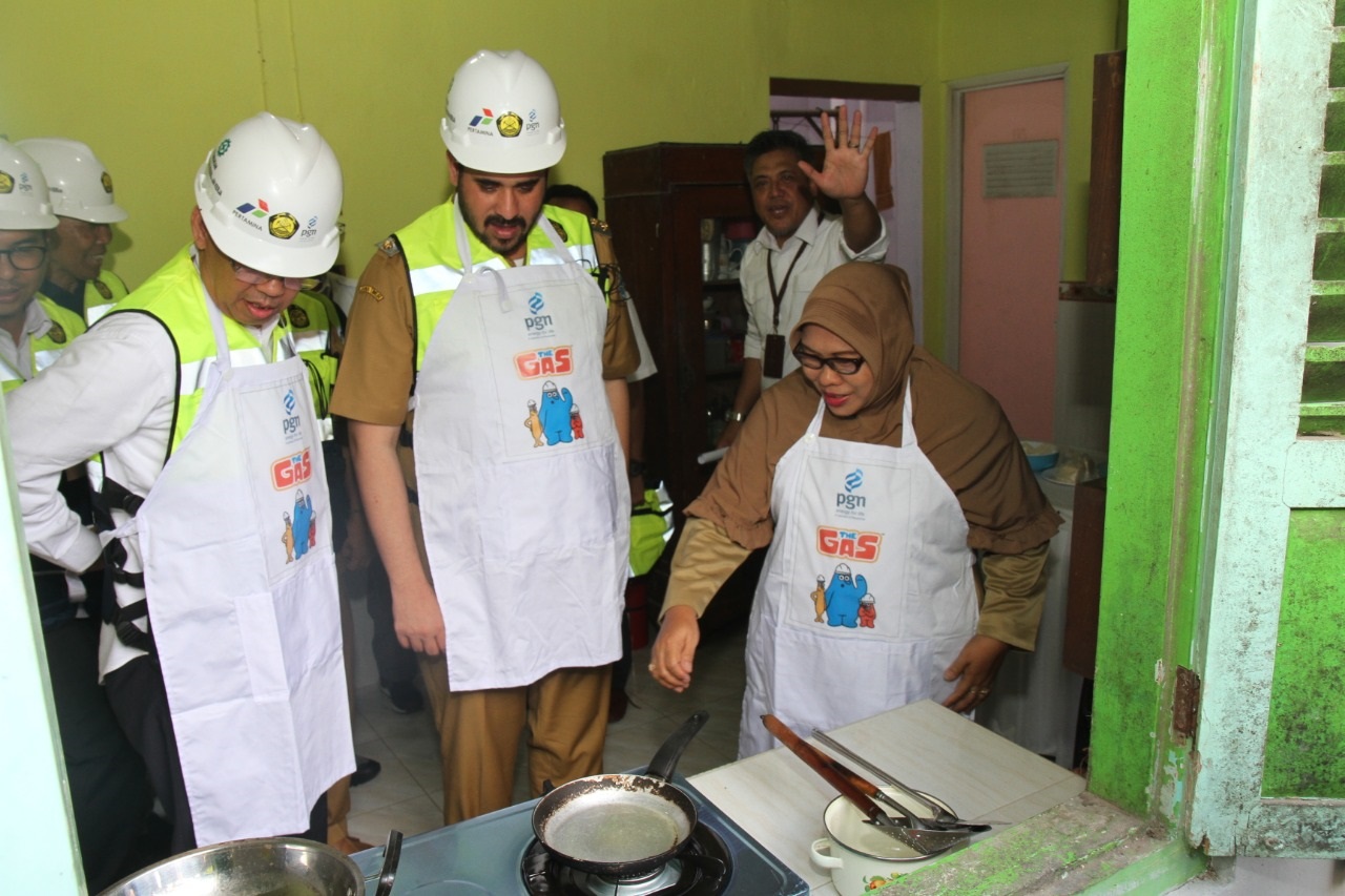 Wali Kota Probolinggo Hadi Zainal Abidin (tengah) saat menyaksikan ibu rumah tangga yang memanfaatkan jaringan gas untuk memasak. (foto: Humas Pemkot/ngopibareng.id).