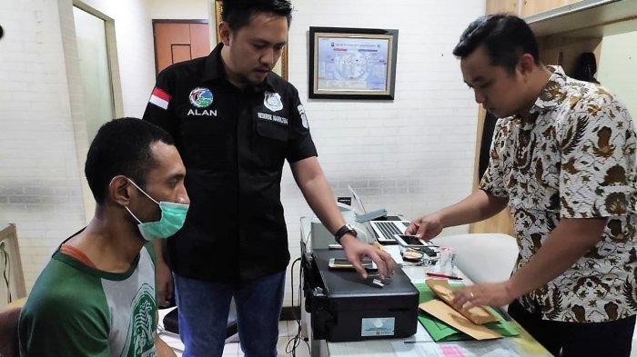 Eddo Charles menutupi wajah dengan masker saat pemeriksaan di kantor polisi.