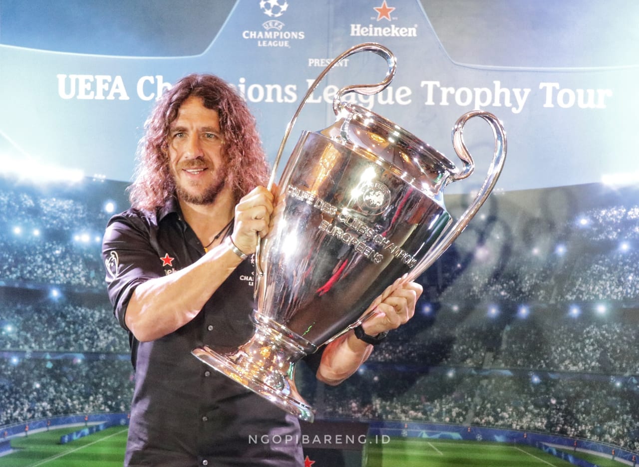 Legenda sepakbola Spanyol, Carles Puyol saat berpose bersama trofi Liga Champions. (Foto: Haris/ngopibareng.id)