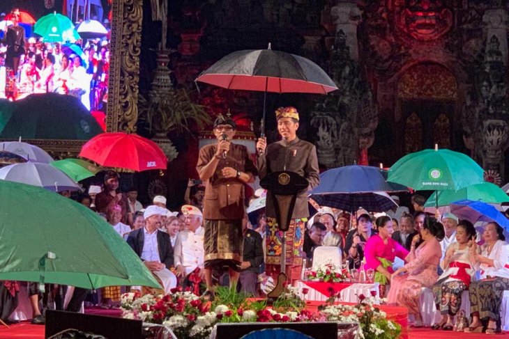 Presiden Jokowi memayungi seorang Bendesa Bali saat berdialog di area terbuka. (Foto: antara)